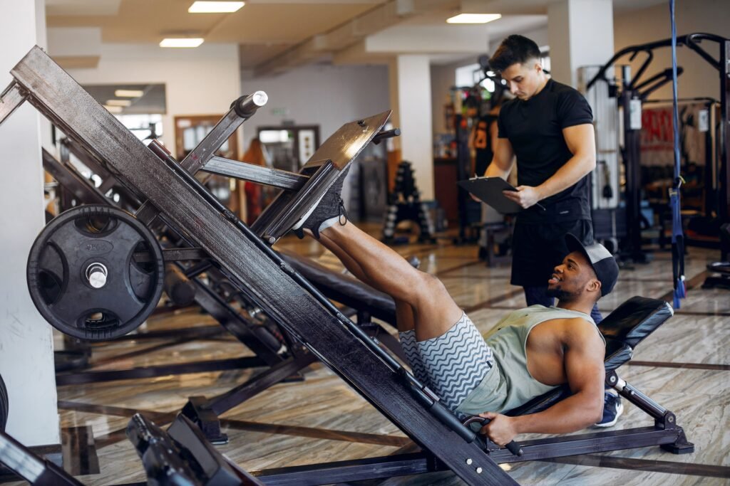 muscular man doing heavy leg press workout for thighs and hips in gym